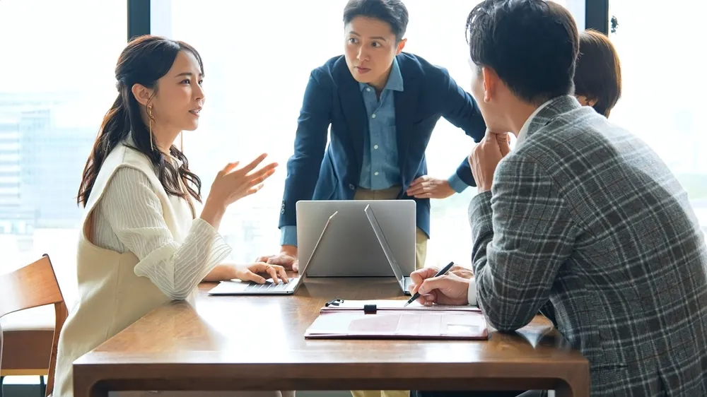 Two business partners in a focused discussion, Tokyo skyline in the background