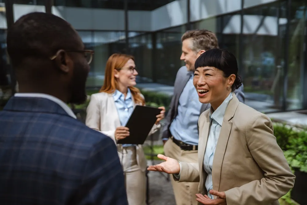 Business colleagues greeting each other outside a modern office