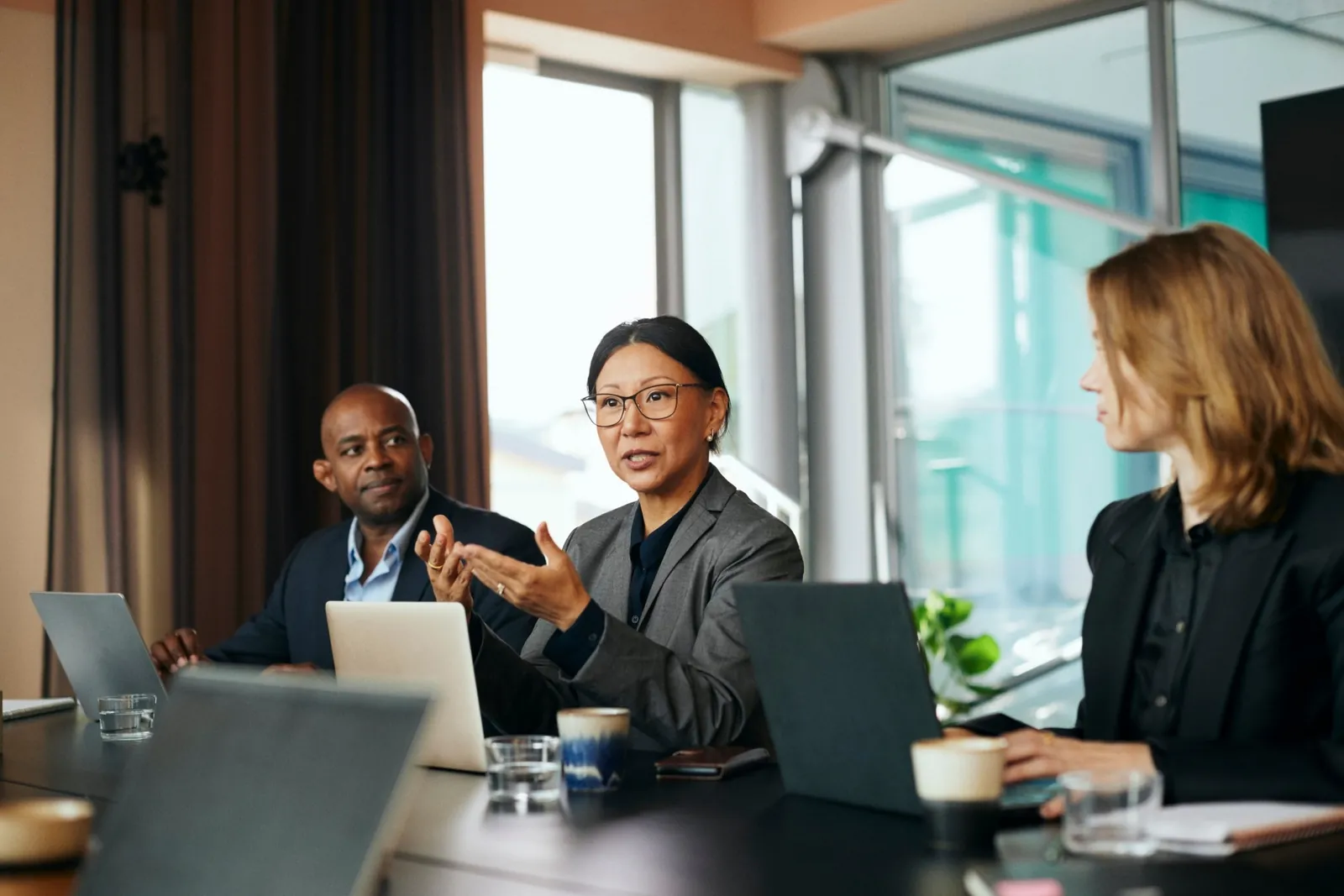 A diverse support team in conversation around a conference table